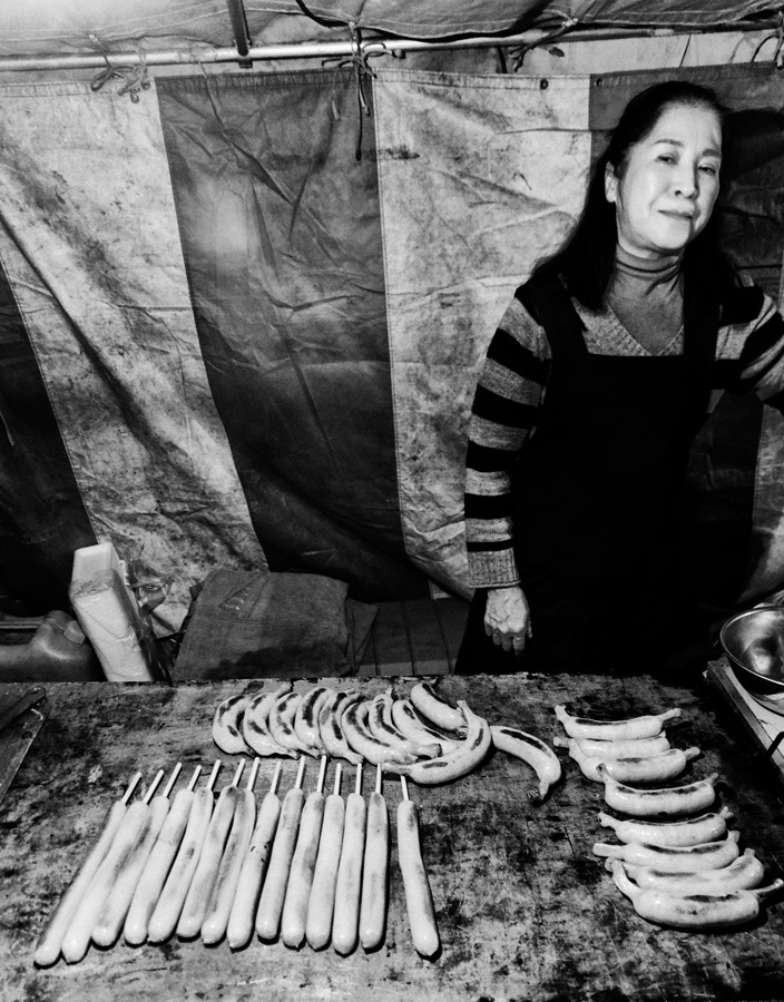 Tokyo – Woman grilling sausages on a festive market in Asakusa