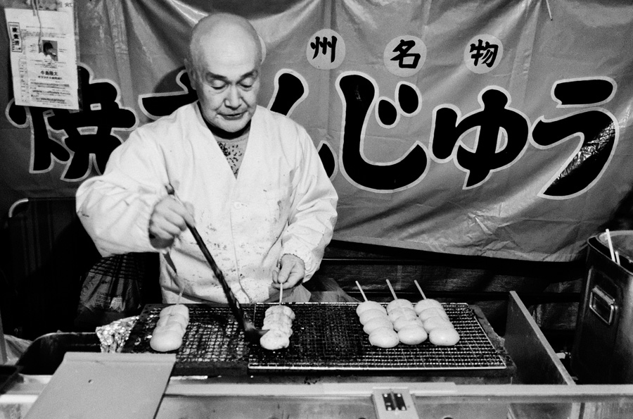 Tokyo – Man offering grilled bread on a festive market in Asakusa