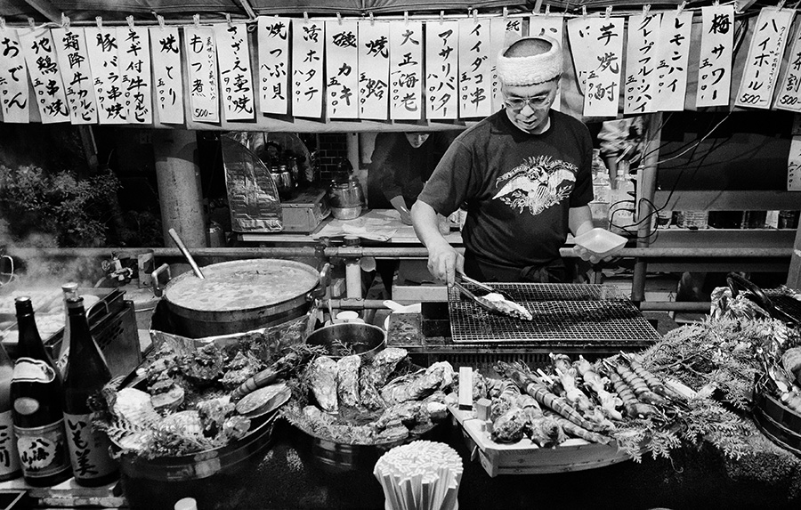 Tokyo – Man preparing grilled sea food on a festive market in Asakusa
